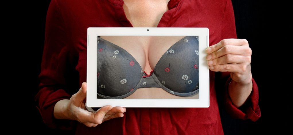breast augmentation, woman holding tablet with photo of bra under clothes